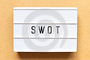 Light box with word swot abbreviation of strength, weakness, opportunities, threats on wood background