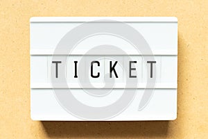 Light box with word ticket on wood background