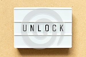 Light box with word unlock on wood background