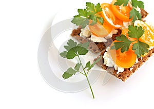 Light Breakfast, healthy food. Crusty bread with soft cottage cheese, tomatoes and parsley.The sandwich is on a white plate,