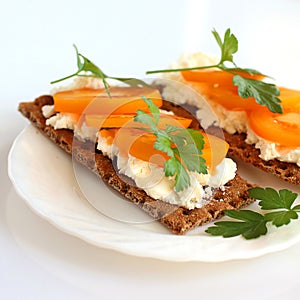 Light Breakfast, healthy food. Crusty bread with soft cottage cheese, tomatoes and parsley.The sandwich is on a white plate,