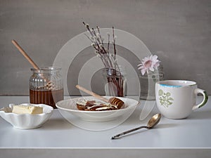 Light breakfast of rye-bread toasts with cereals with butter and honey. Tea in a ceramic mug.