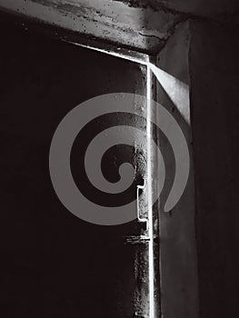 Light breaks through the door. War time. Cellar. The war in Ukraine. Black and white photo.