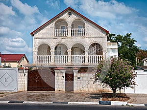 Light brick two-storey house with iron gates