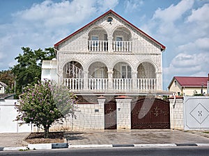 Light brick two-storey house with iron gates