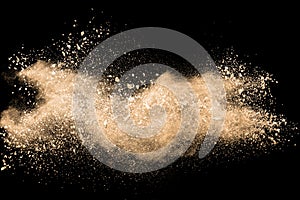 Light brown dust explosion cloud.Brown particles splatter on black background