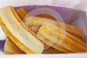 Light brown fired spanish Churros, spiral dough in paper bag photo