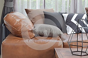 Light brown leather sofa bed with varies color and size pillows