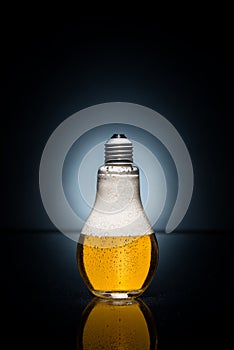 Light bulb beer with drops and ice