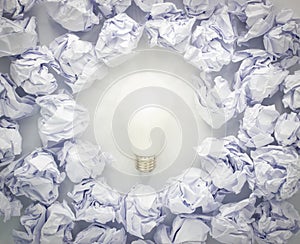 Light bulb with crumpled paper ball isolated on white background.Idea