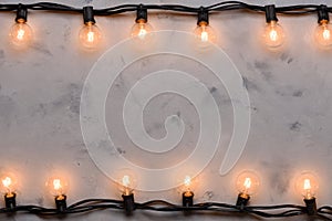 Light bulb garland glowing on concrete table