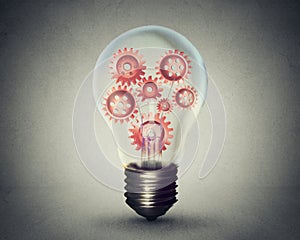 Light bulb with gears and cogs working together