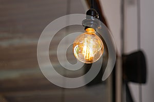 Light bulb hang on ceiling with rustic wall