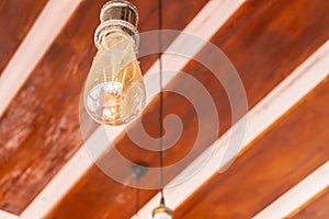 Light bulb hanging on wooden ceiling