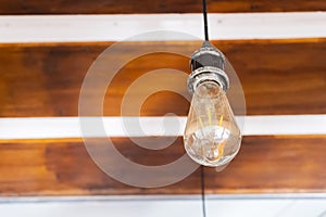 Light bulb hanging on wooden ceiling