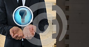 Light bulb icon and Businessman with hands palm open in city