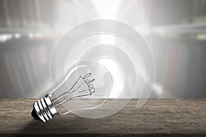 Light bulb with Idea word wire shape on wooden table