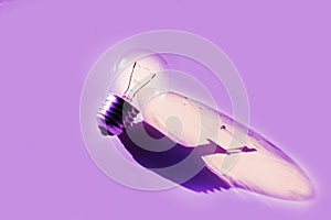 Light bulb with reflection on purple background