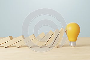 Light bulb stopping wooden block domino effect for business