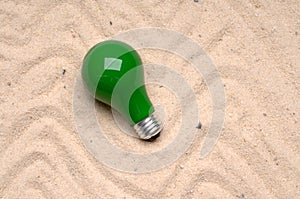 Light bulb tossed on the sand