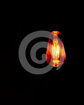 Light bulb with warm light on black background
