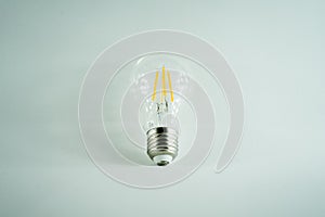 Conceptual light bulb in minimalist white background photo