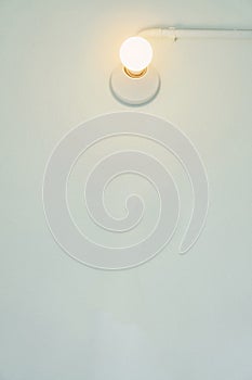 Light bulb on white wall. Fits into the background or the wallpapers. photo