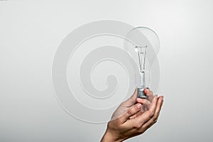 Light bulb in a woman`s hands. Free space for text and copy space