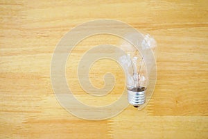 A light bulb on the wooden texture background