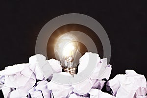 Light bulbs and crumpled paper on black background. Good idea and inspiration concept.