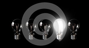 Light bulbs with glowing one outstanding dark background.Business, motivation concept ideas. photo