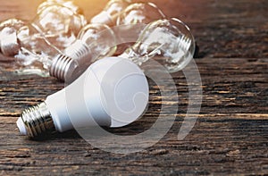 Light bulbs with glowing on wooden table background. Idea, creativity and saving energy with light bulbs concept.