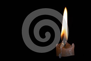 Light candle burning brightly in the black background