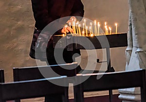 Light a candle in a Christian church to commemorate the deceased