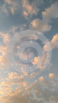 Light clouds in the blue sky at sunset. Vertical background