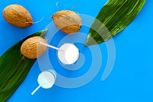 Light cocktail with coconut milk. White tropical beverage in glasses with straw on blue background with coconut and palm