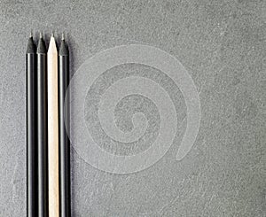 Light Coloured Pencil Among Three Black Ones