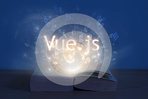 Light coming from open book with words vue js. Education concept. Learn programming language