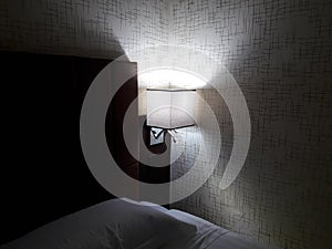 Light at the corner of bed room,shadow in dark blur bed room.