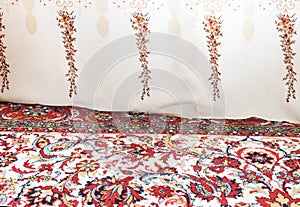 Light curtain fabric lies on a vintage carpet in the apartment.