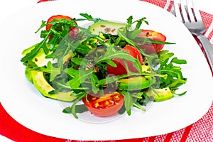 Light dietary salad from arugula, avocado, tomates and flax seed