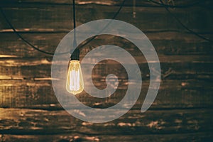 Light Edison bulb on dark wooden background