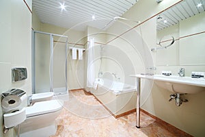 Light and empty bathroom with white bath, toilet