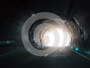 Light at end of dark highway tunnel with glowing exit. Hope, direction, breakthrough and progress, modern transportation