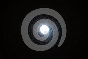 The light at the end of the tunnel concept. The old deep abandoned well. Inside view.