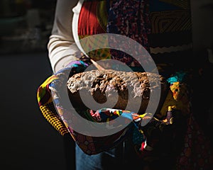 Light Falling on Person Holding a Loaf of African Seed Bread