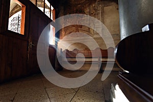 light falling through window in old church on wooden bench, peaceful moment