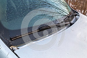 light frost flakes on morning car windshield and waterblade wipers