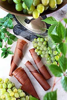 Light grapes and vintage scales. Pastilla from grapes. Natural product without preservatives. Food for vegetarians. Bunches of