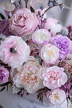 Light gray concrete planter with flowers. Gently pink anemones, pink roses and cream peonies with eucalyptus